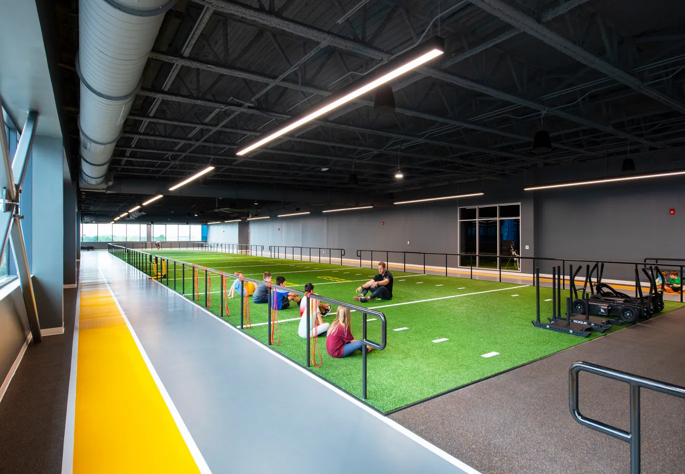 Athletes and fitness members training on the indoor track and turf at LNPC in Lake Nona